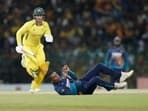 Sri Lanka's Jeffrey Vandersay, bottom, attempts unsuccessfully to field a ball as Australia's Alex Carey runs between wickets during the fifth one-day international cricket match between Australia and Sri Lanka in Colombo, Sri Lanka, Friday, June 24, 2022.