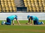 Australia captain Pat Cummins with teammate David Warner examines the pitch during a practice session ahead of the 1st Test in Nagpur