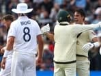 Australia's Pat Cummins (R) celebrates with Australia's Nathan Lyon after winning the first Ashes Test 