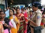 A woman Police personnel checks a voter ID card of a woman voter who arrived to cast her vote for the West Bengal Panchayat election in North 24 Parganas district on Saturday. (ANI)  
