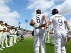 England's Stuart Broad is pushed ahead by James Anderson to receive a guard of honour from the Australian players 