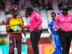 Nicholas Pooran (L) of the West Indies chats with umpires Leslie Reifer Jr. (C) and Nigel Duguid (R) during the 2nd T20I match between West Indies and India at Guyana National Stadium in Providence, Guyana, on August 6