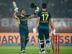 Australia's Josh Inglis celebrates after scoring a century (100 runs) as his teammate Marcus Stoinis (R) watches 