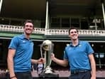 Australian cricketers Mitchell Starc (L) and team captain Pat Cummins pose with the ICC Men's Cricket World Cup 2023 Trophy during a media opportunity at the Sydney Cricket Ground on November 28, 2023