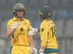 Australia's Ellyse Perry, left, celebrates after scoring 50 runs with her team player Phoebe Litchfield