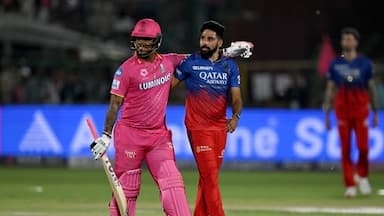 Rajasthan Royals' Shimron Hetmyer (L) and Royal Challengers Bengaluru's Mohammed Siraj (C) look on at the end of the Indian Premier League (IPL) Twenty20 cricket match between Rajasthan Royals and Royal Challengers Bengaluru 