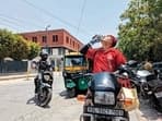 A Zomato delivery agent quenches his thirst before going on his delivery rounds