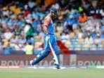 India's Virat Kohli walks back to the pavilion after being dismissed by Afghanistan's captain Rashid Khan.
