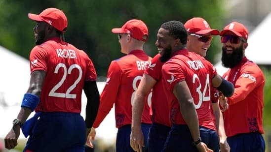 England's Chris Jordan, third right without cap, celebrates with teammates after getting a hat-trick by dismissing United States' Saurabh Netralvakar