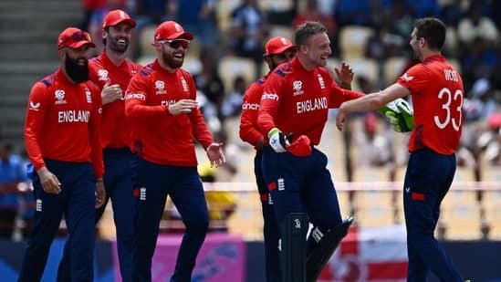 England's Mark Wood (R) celebrates with England's captain Jos Buttler and teammates after running out South Africa's Heinrich Klaasen during the ICC men's Twenty20 World Cup 