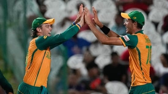 South Africa's Tristan Stubbs, left, celebrates with teammate Marco Jansen after taking a catch to dismiss Afghanistan's Azmatullah Omarzai