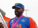 India's captain Rohit Sharma poses for a picture with the trophy after Team India wins the ICC Mens T20 World Cup 2024 