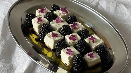 A salad made with blackberries with feta cheese and edible flowers 